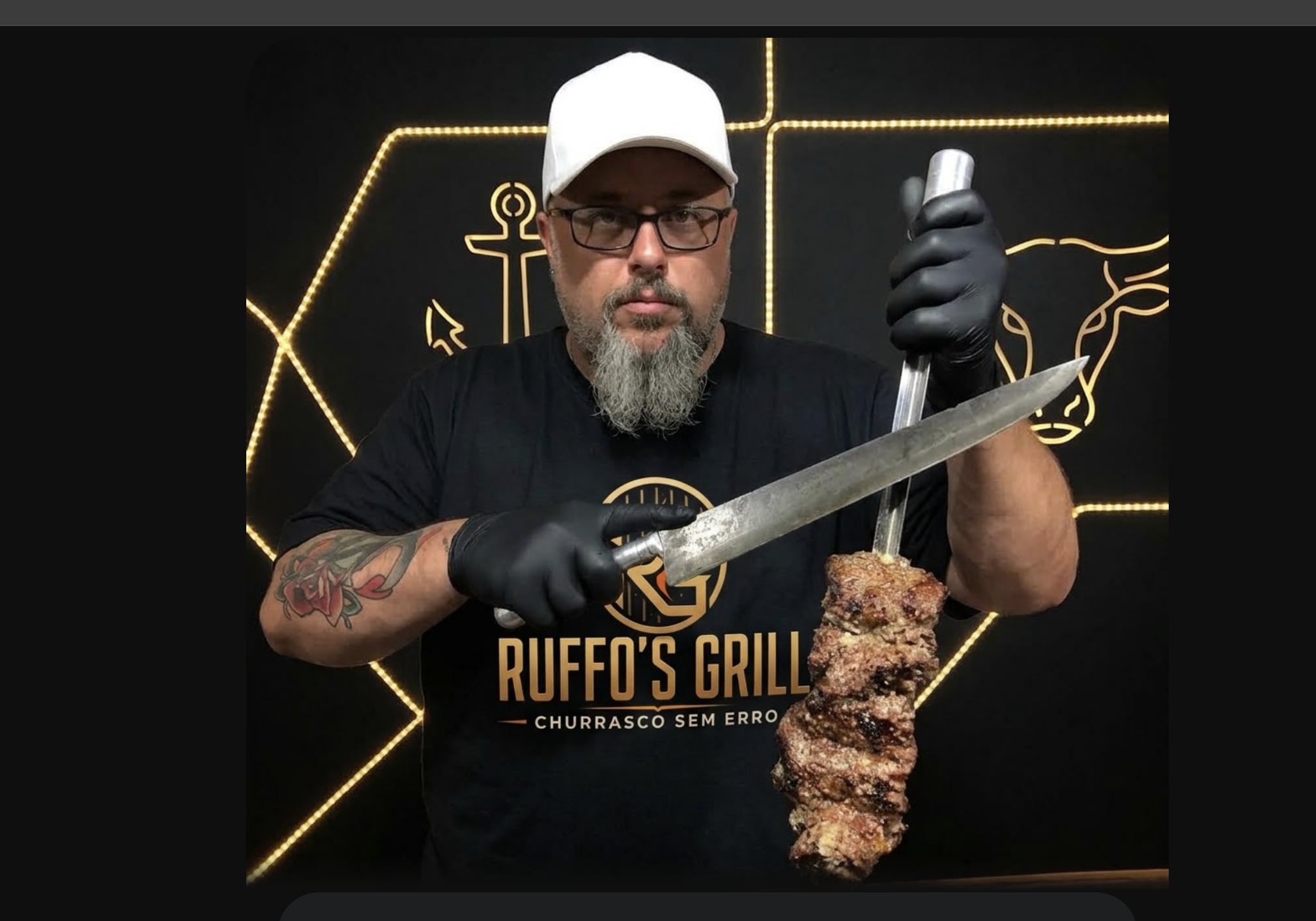 André, da Ruffo's Grill, segurando um espeto de carne e uma faca